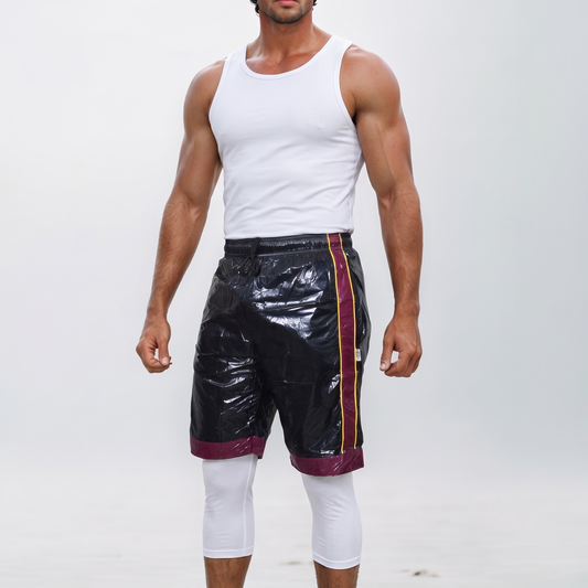 Black shiny PU nylon shorts with red and yellow side stripes, studio look